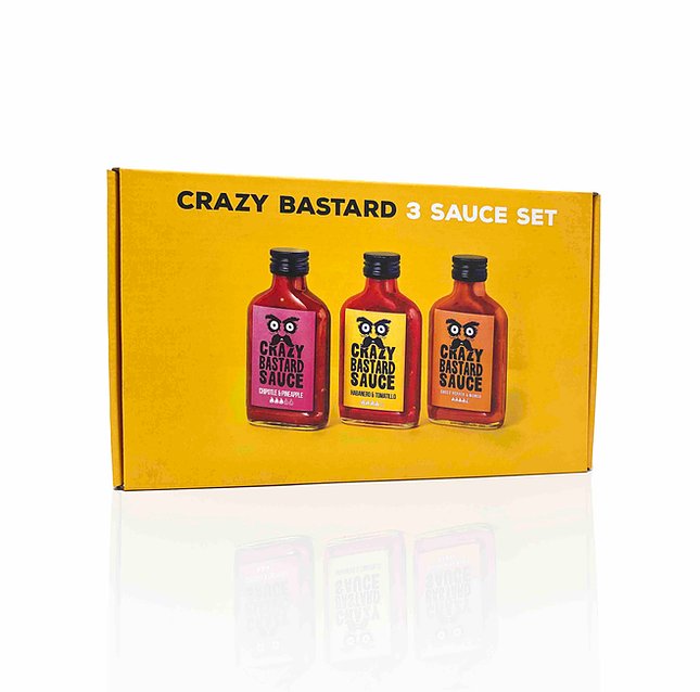 Trois flacons de sauces épicées sur fond blanc.