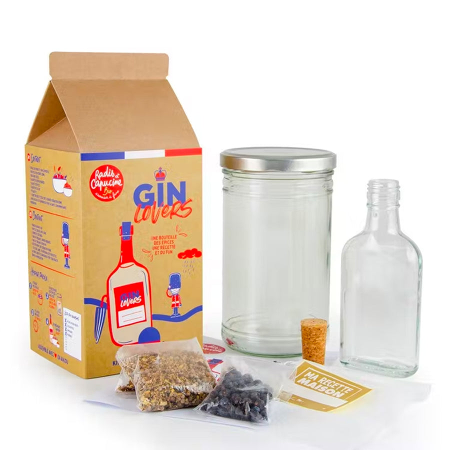 Kit DIY pour gin avec ingrédients et accessoires sur fond clair.