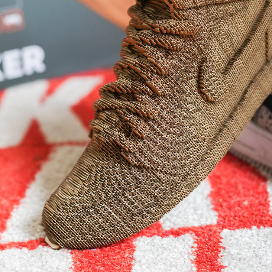 Sculpture en carton de sneakers vue de côté, détails précis.