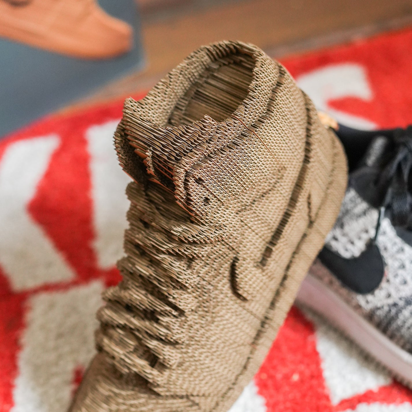 Sculpture en carton DIY de sneakers vue de côté avec détails colorés.