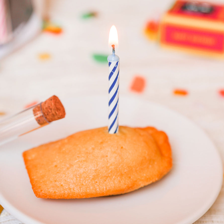 Bougie colorée dans un tube à essai transparent, vue de côté.