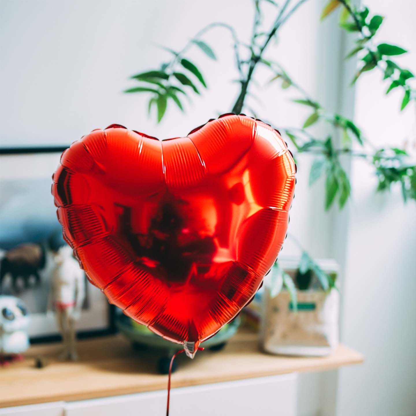 Ballon en forme de cœur rouge flottant avec une carte personnalisée.
