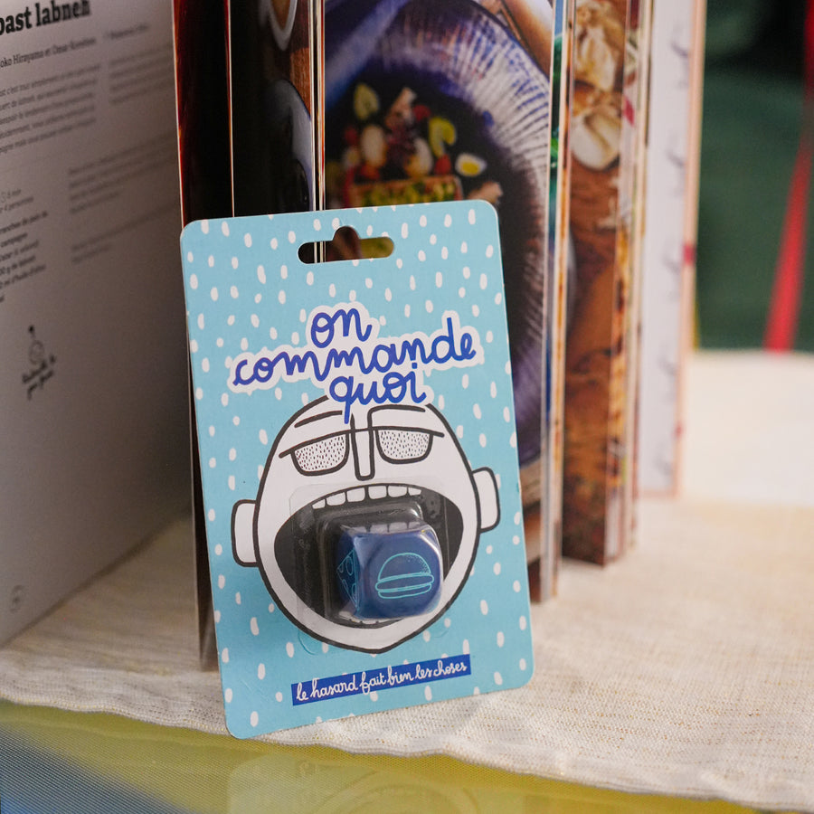 Dé en bois avec inscriptions colorées sur chaque face.