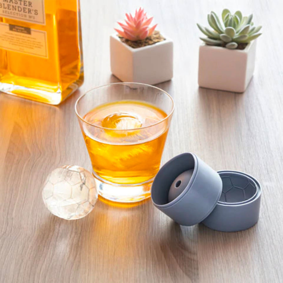 Moule à glaçons en forme de ballon de football sur fond blanc.